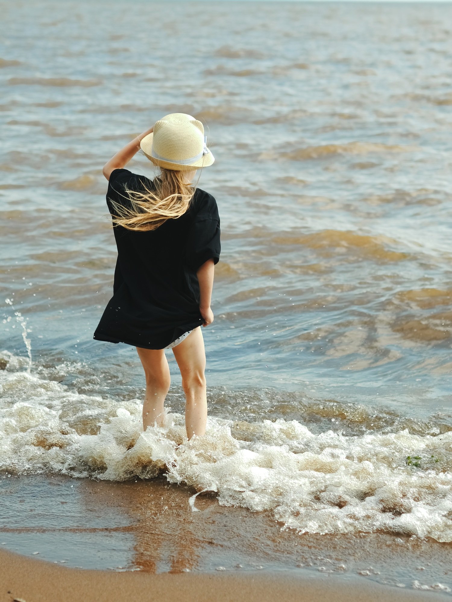 Little girl at the sea. Seascape. Vacation at the seaside. View back